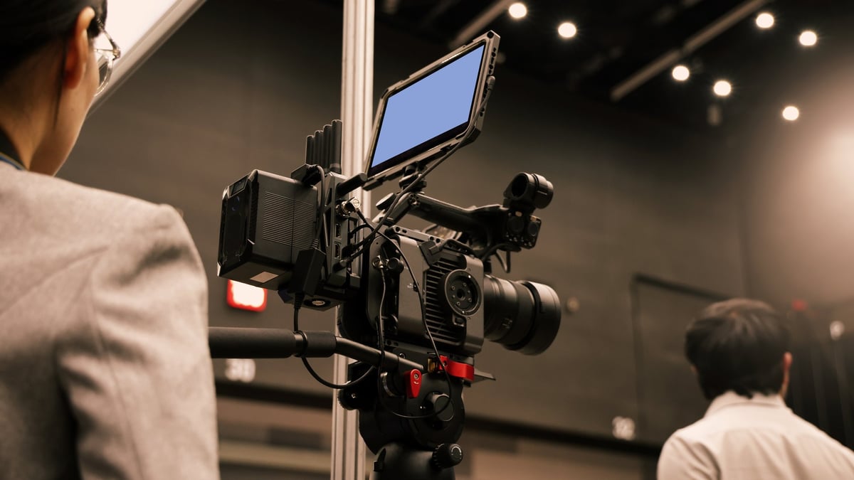 Professional video crew filming with high-end cinema cameras in a studio production environment